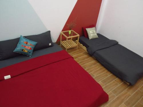 een slaapkamer met 2 bedden en een rode deken bij HO GIA AN Home - Double Room in Can Tho