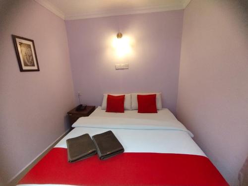 a bedroom with a bed with red pillows and a red blanket at HOTEL PANTAI VIEW in Labuan