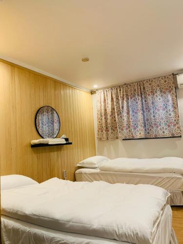 ein Zimmer mit drei Betten und einem Fenster in der Unterkunft SSH LK Hostel in Seoul