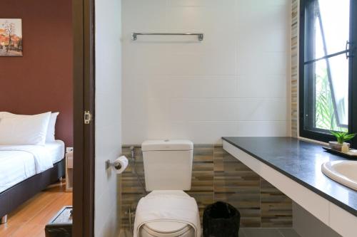 a bathroom with a toilet and a sink at Baan Kieng Tawan in Khong Chiam