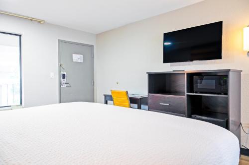 a hotel room with a bed and a flat screen tv at Days Inn by Wyndham Augusta Fort Eisenhower in Augusta
