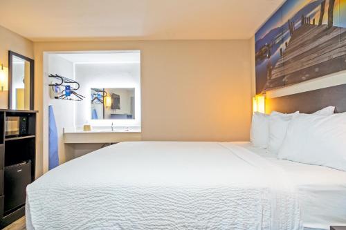 a hotel room with a large bed and a sink at Days Inn by Wyndham Augusta Fort Eisenhower in Augusta