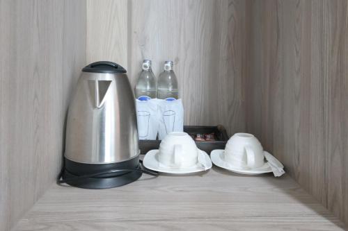 a coffee maker and two plates and bottles of water at Baan Kieng Tawan in Khong Chiam