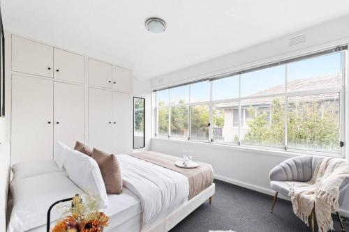 een witte slaapkamer met een bed en een raam bij The Bluewater Nest in Melbourne