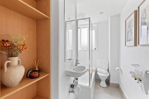 een witte badkamer met een wastafel en een toilet bij The Bluewater Nest in Melbourne