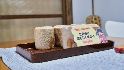 a wooden tray with two rolls of food on a table at BLUE HOUSE - Traditional Home - 5min, Beach, Bus, Train in Beppu