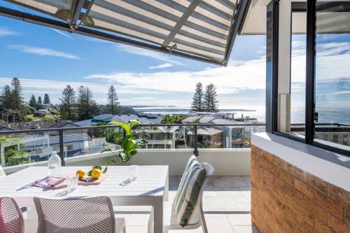 a balcony with a table and chairs and a view at Namanula 7 - oceanstays in Yamba