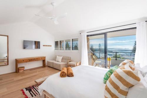 a bedroom with a large bed and a large window at Namanula 7 - oceanstays in Yamba