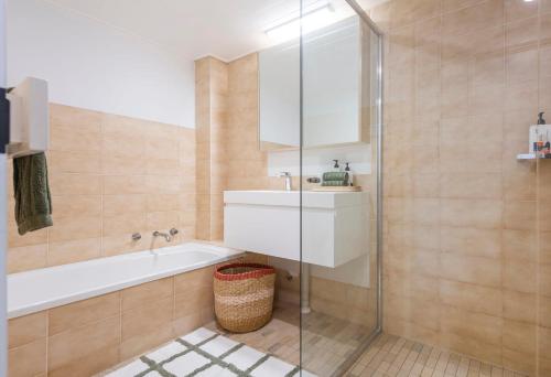 a bathroom with a shower and a sink and a tub at Namanula 7 - oceanstays in Yamba