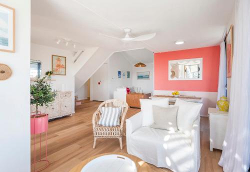 a living room with white furniture and red walls at Namanula 7 - oceanstays in Yamba