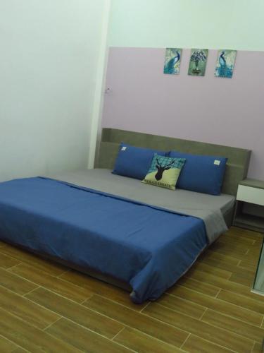 un letto in una stanza con cuscini blu di HO GIA AN Home - King Room a Ấp Lợi Ðủ