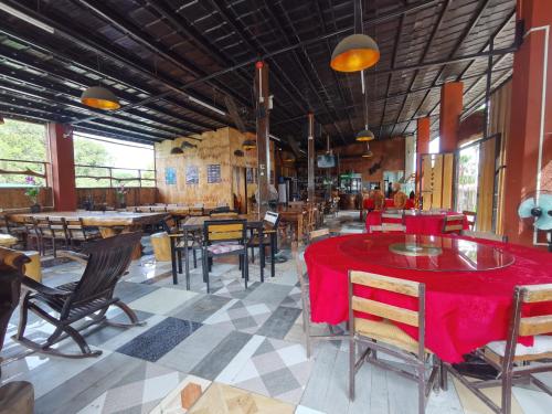 comedor con mesa roja y sillas en Panda Guest House en Corón