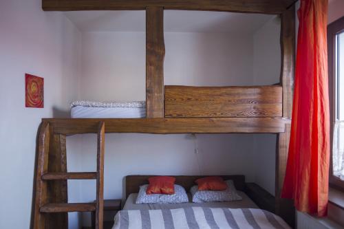 two bunk beds in a room with a ladder at Bike Bistro a penzion U Všech andělů in Nové Město pod Smrkem