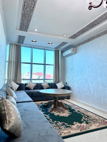 a living room with a couch and a table at Abraj Dubai Larache in Larache