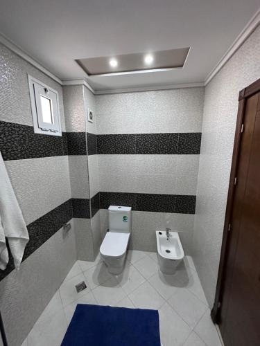 a bathroom with a toilet and a sink at Abraj Dubai Larache in Larache