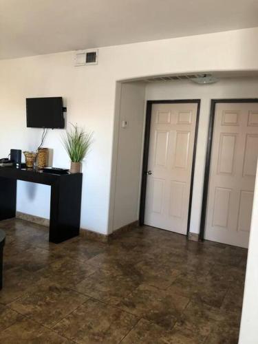 a room with two doors and a table and a television at Loft A cerca zona dorada in Mexicali