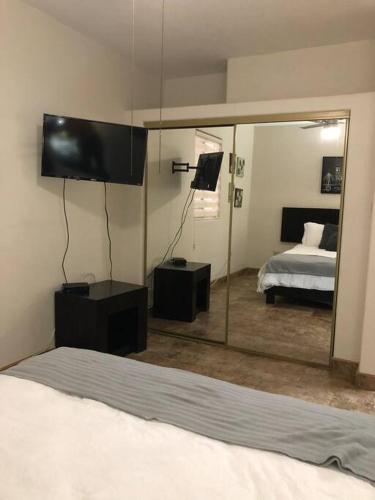 een slaapkamer met een bed en een grote spiegel bij Loft A cerca zona dorada in Mexicali