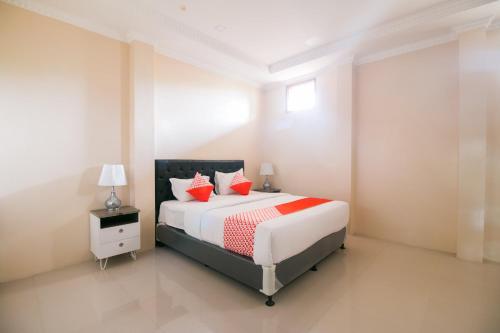 a bedroom with a large bed with red pillows at Hotel O Edotel Smkn 1 Pacet Syariah in Puncak