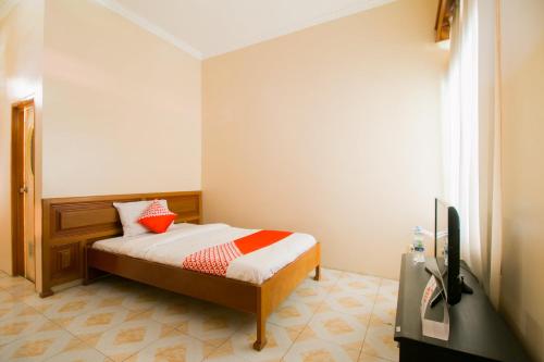 a small bedroom with a bed and a television at OYO 1667 Edotel Smkn 1 Pacet Syariah in Puncak