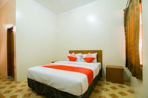 a bedroom with a bed with red and white pillows at Hotel O Edotel Smkn 1 Pacet Syariah in Puncak