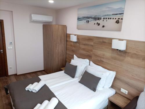 a bedroom with a bed with white sheets and pillows at Hotel Vanilla, Varna - Free parking in Varna City