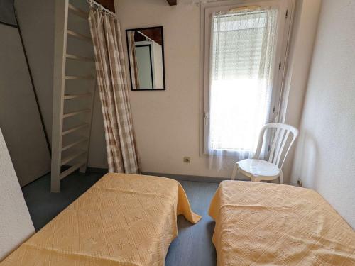 Cette chambre dispose d'un lit, d'une échelle et d'une fenêtre. dans l'établissement Maison proche plage, commerces, 6 pers., terrasse, parking privé, option Internet, animaux non admis - FR-1-387-196, à Marseillan