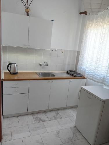 a kitchen with white cabinets and a sink at La Mira House in Neos Marmaras