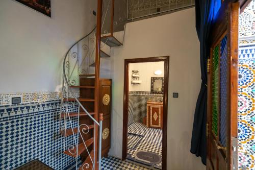 een trap naar een kamer met blauwe en witte tegels bij Riad Tarab Fes in Fès