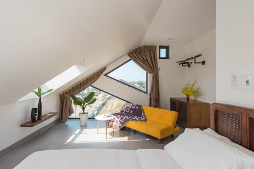 會安的住宿－Basil Boutique Villa by Class6，阁楼卧室配有床和黄色椅子