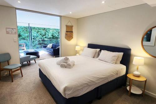 雪梨的住宿－Stylish parkside retreat，一间卧室,床上放着两只动物