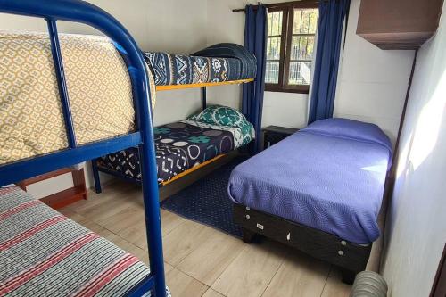 Cette chambre comprend deux lits superposés et un petit lit. dans l'établissement Casa en la península de Tongoy, à Tongoy