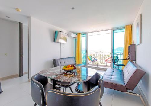 a dining room with a table and chairs and a balcony at Nuevo, Hermoso y a 2 minutos de la Playa in Gaira
