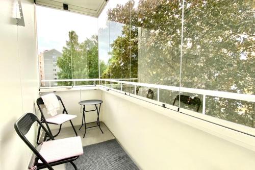 a balcony with two chairs and a table and a window at Beautiful 2 bedroom & Free parking in Turku