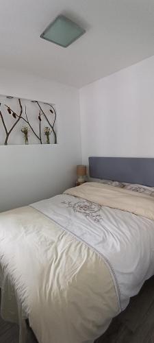 Un dormitorio con una cama blanca con una foto en la pared en Studio 1 Cabana de pe Stanca, en Colibiţa
