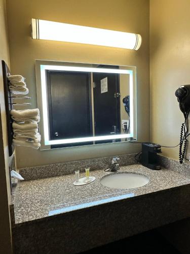 a bathroom with a sink and a mirror at Super 8 by Wyndham Eau Claire WI in Eau Claire