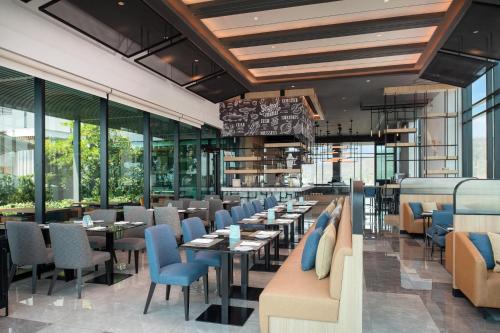 a restaurant with tables and chairs and windows at KensingtoN Laemchabang-Sriracha, Special rate for monthly rent, Cozy Style of Living and near Kasetsart University in Ban Ao Udom