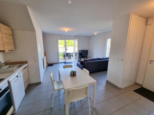 une cuisine et un salon avec une table et des chaises dans l'établissement La Cabane Fournier 10 min a pied de Mimizan plage et commerce, à Mimizan