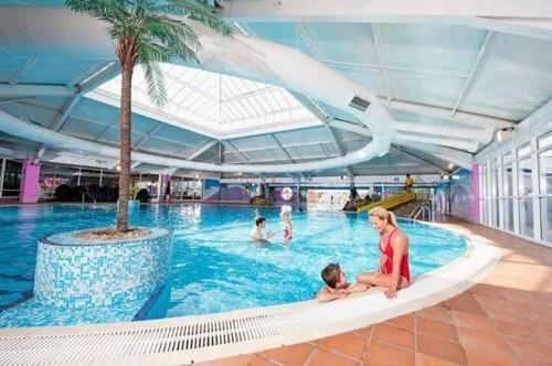 una donna e un bambino seduti in piscina di Spacious Caravan - Thorpe Park Cleethorpes a Humberston