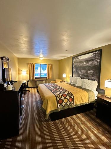 a hotel room with a bed and a desk at Super 8 by Wyndham Eau Claire WI in Eau Claire