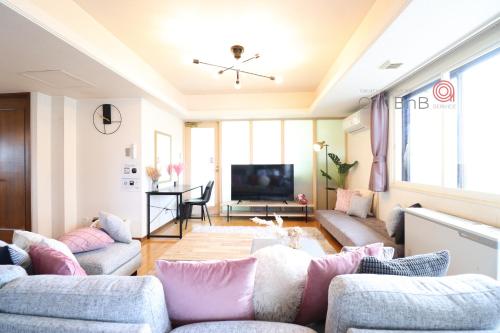 a living room with couches and a flat screen tv at NK BLD5F Sapporo 3LDK 3BR 1 floor 1 room in Sapporo