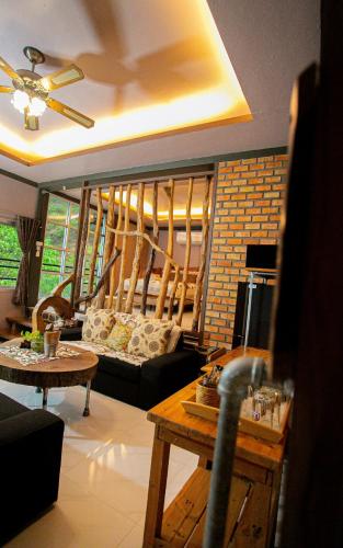 a living room with a couch and a table at Lodge Phang nga boutique in Ban Khaek