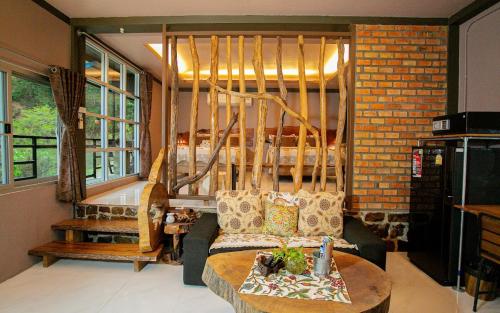 a living room with a couch and a table at Lodge Phang nga boutique in Ban Khaek