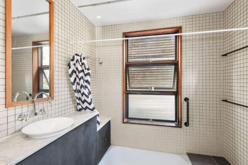 uma casa de banho com um lavatório e uma janela em Kangarilla em Emerald Beach