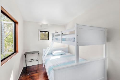 a white room with a bunk bed and a window at Kangarilla in Emerald Beach