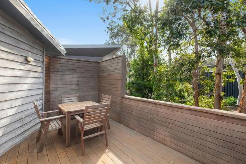 a wooden table and chairs on a wooden deck at Kangarilla in Emerald Beach