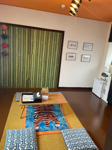 a living room with a table and a rug at 777 Takamatsu Guest House in Takamatsu