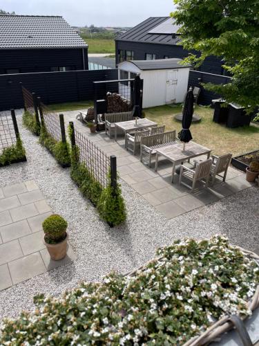 a patio with tables and chairs and some flowers at Kallehavegaard Badehotel in Løkken