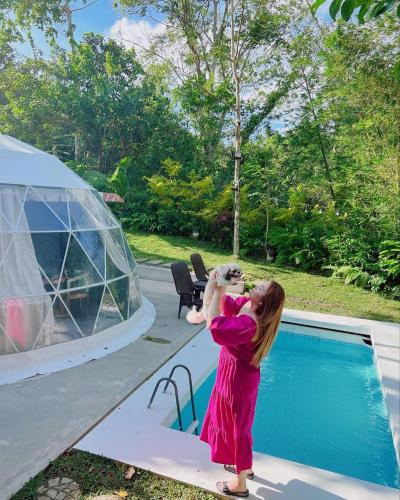 a young girl is standing next to a swimming pool at Shanti Wellness Sanctuary in Lemery