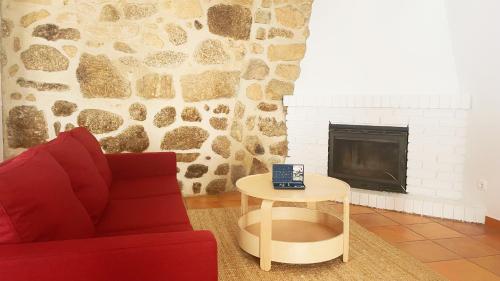 a living room with a couch and a table and a fireplace at Casa de Partida in Covilhã