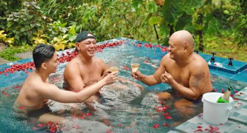 three men are drinking wine in a hot tub at Shanti Wellness Sanctuary in Lemery